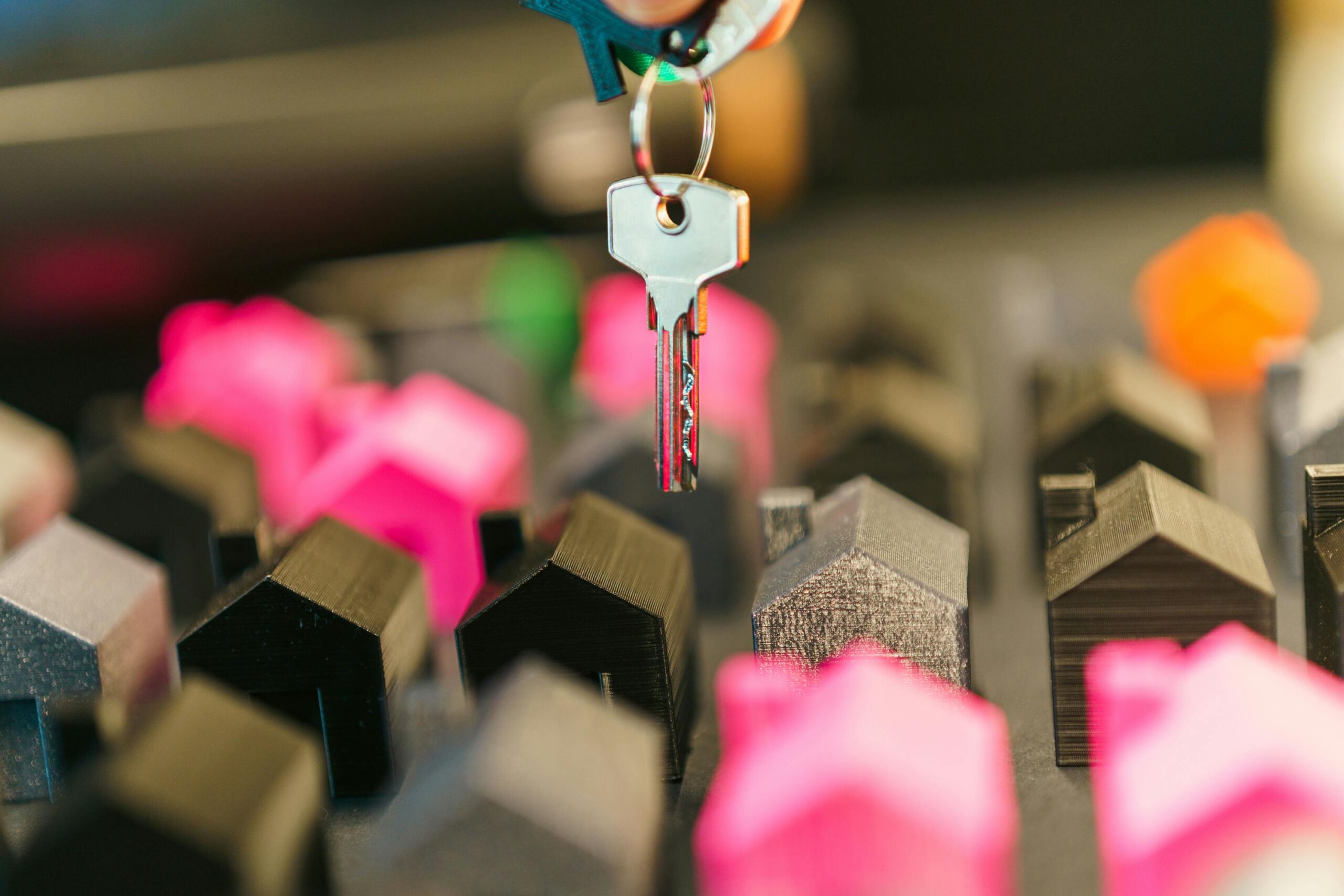 A key floating on top of miniatuure houses.