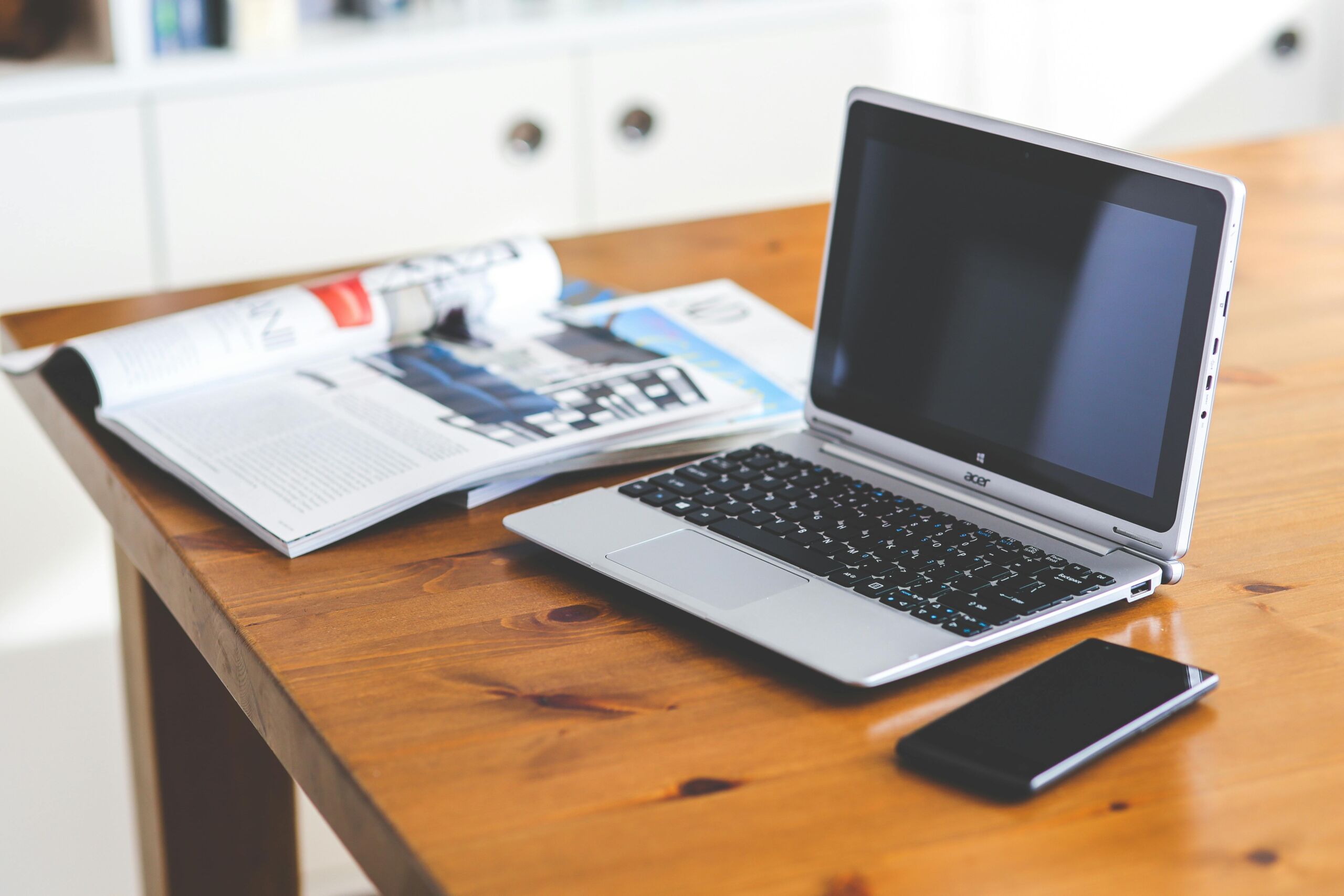A laptop and a planner placed neatly on a wooden table.